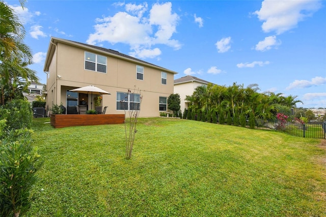 1416 Cabot Dr, Clermont, FL 34711 - rear view of property with stucco siding, fence, and a lawn