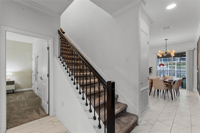 staircase with ornamental molding, a notable chandelier, and carpet flooring