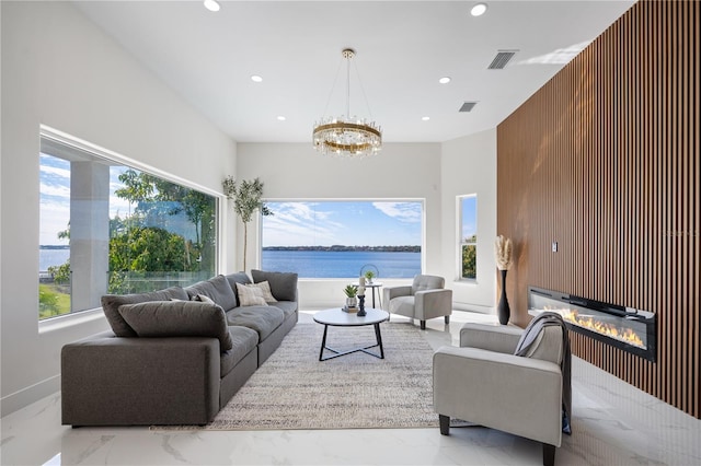 living room featuring a water view, an inviting chandelier, and wood walls