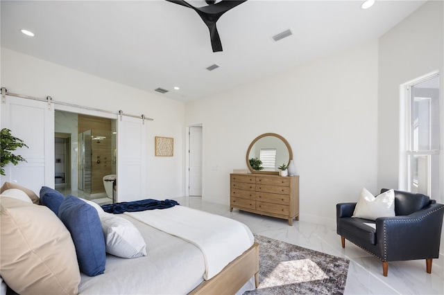 bedroom featuring ensuite bathroom, a barn door, and ceiling fan