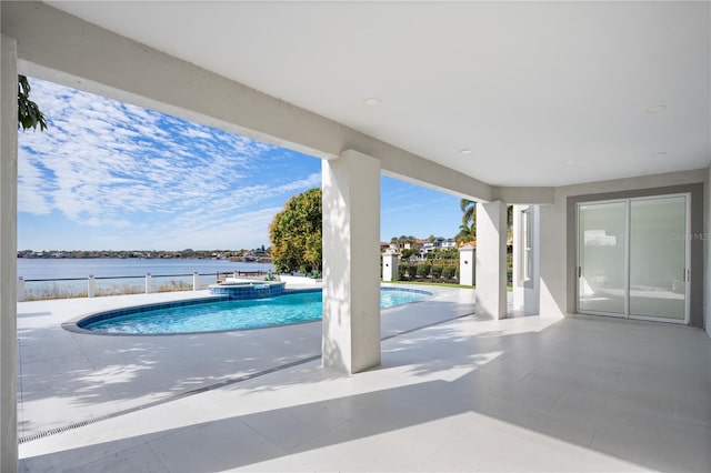 view of pool with a patio, a water view, and an in ground hot tub