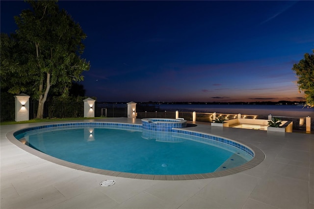 pool at dusk with a water view, an in ground hot tub, and a patio area