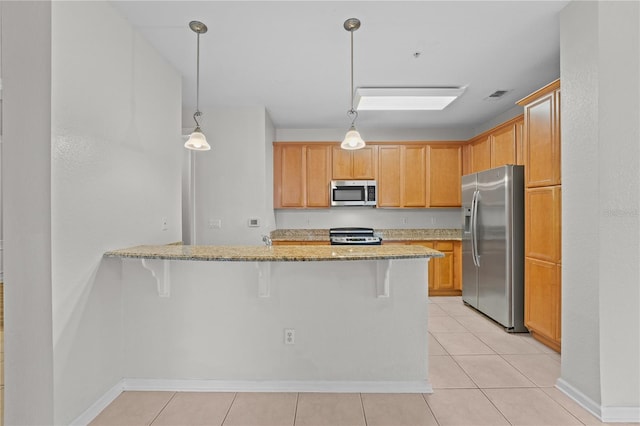 kitchen featuring stainless steel appliances, light tile patterned floors, hanging light fixtures, and kitchen peninsula