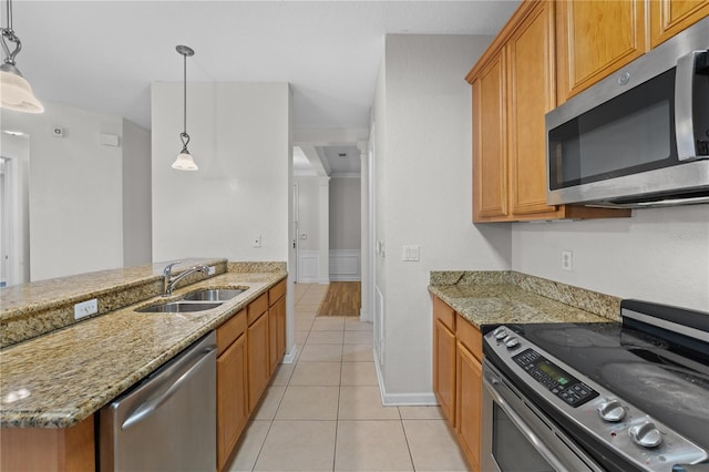 kitchen featuring decorative light fixtures, stainless steel appliances, light tile patterned flooring, and sink