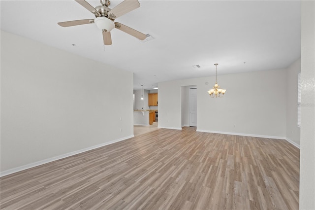 unfurnished living room with ceiling fan with notable chandelier and light hardwood / wood-style floors