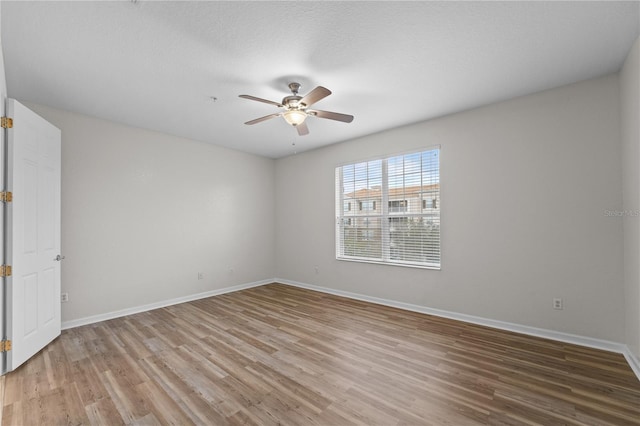 empty room with ceiling fan and wood-type flooring