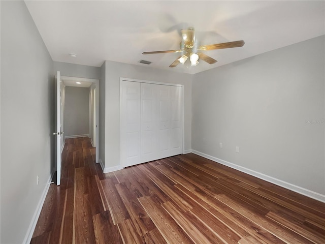 unfurnished bedroom with ceiling fan, a closet, and dark hardwood / wood-style floors