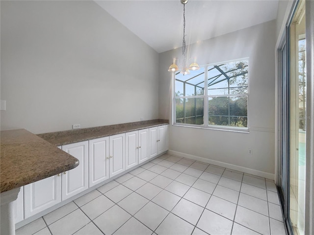 unfurnished dining area featuring vaulted ceiling, a notable chandelier, and light tile patterned flooring