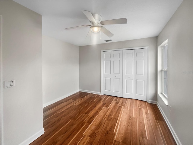 unfurnished bedroom featuring a closet, hardwood / wood-style flooring, and ceiling fan