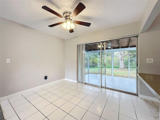 tiled spare room with ceiling fan