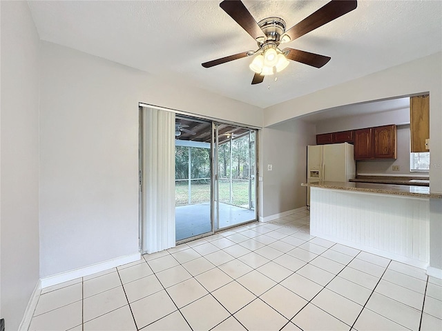 kitchen featuring ceiling fan, light tile patterned floors, and white refrigerator with ice dispenser