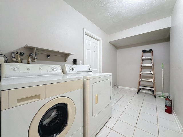 clothes washing area with light tile patterned floors and separate washer and dryer