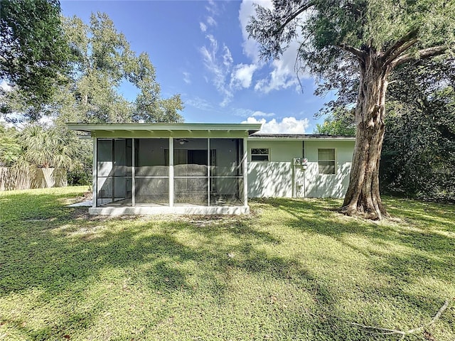 back of house featuring a yard and a sunroom