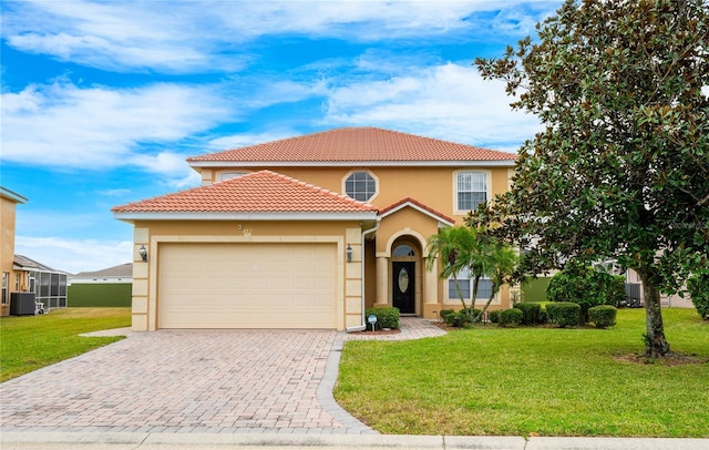 mediterranean / spanish home featuring cooling unit, a garage, and a front yard