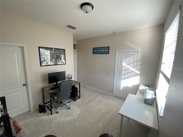 carpeted office space with a textured ceiling