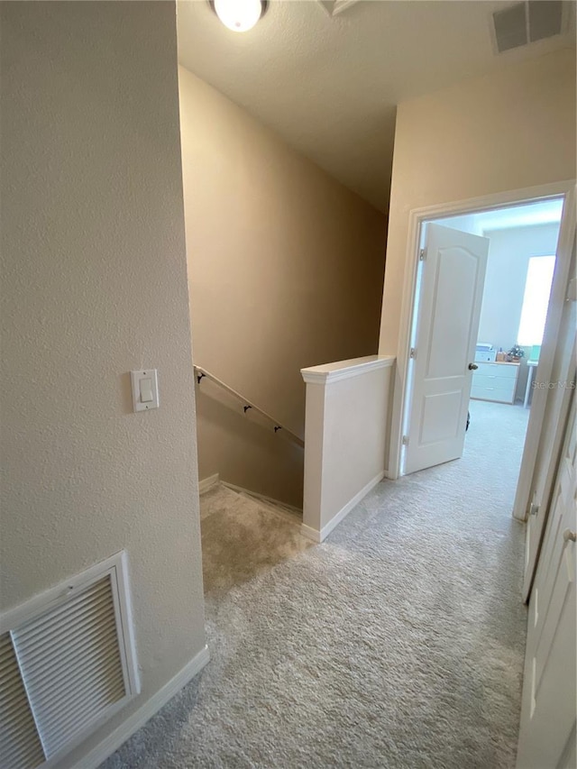 hall featuring light colored carpet