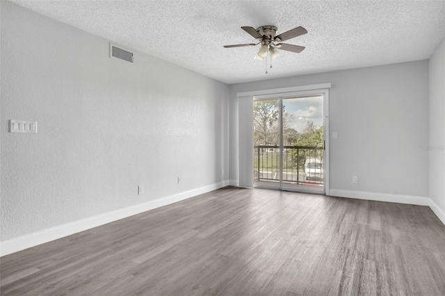 unfurnished room featuring a textured ceiling, dark hardwood / wood-style floors, and ceiling fan