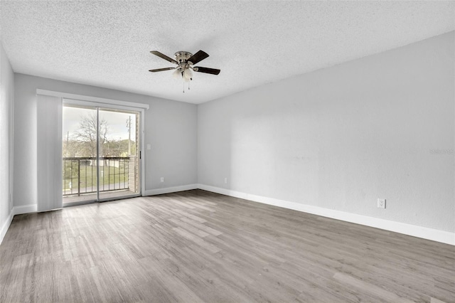 empty room with a textured ceiling, wood-type flooring, and ceiling fan