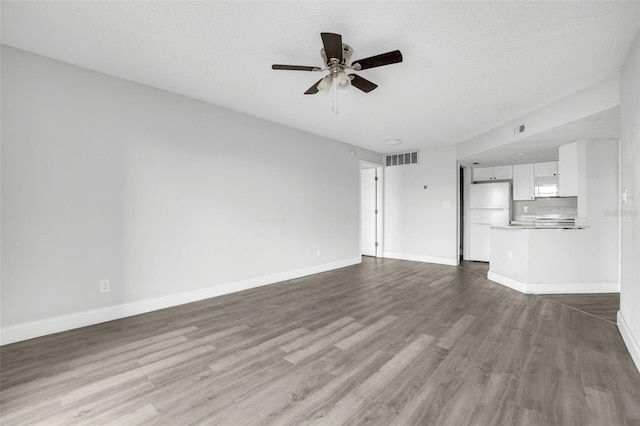 unfurnished living room featuring ceiling fan, a textured ceiling, and light hardwood / wood-style floors