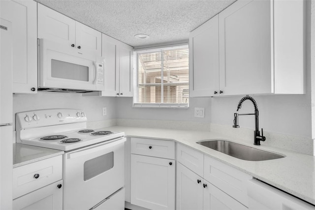 kitchen with sink, a textured ceiling, white cabinets, and white appliances