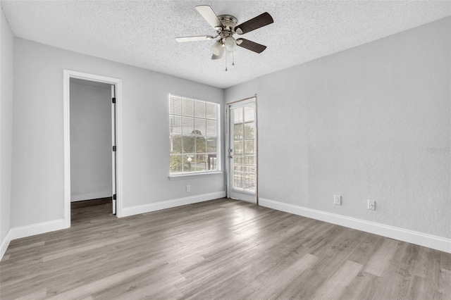 empty room with ceiling fan, light hardwood / wood-style floors, and a textured ceiling