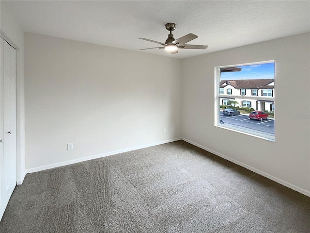 spare room featuring ceiling fan and carpet