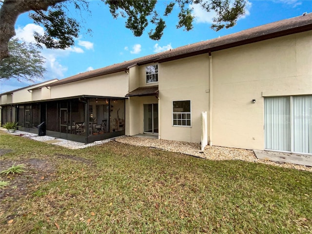 rear view of property with a yard and a sunroom