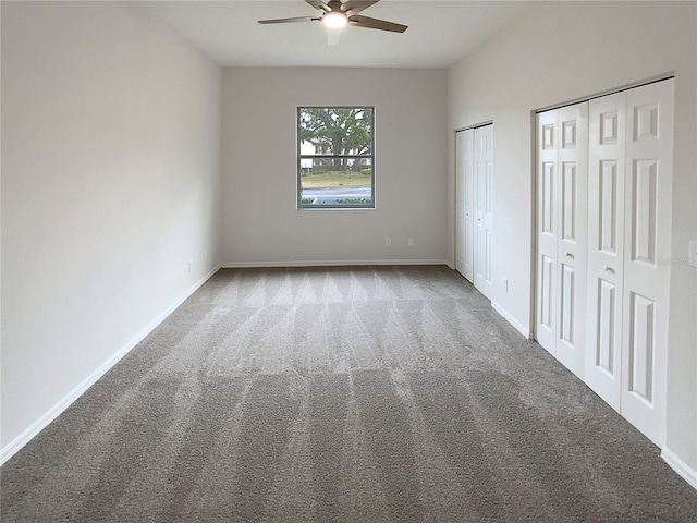 unfurnished bedroom featuring ceiling fan, two closets, and carpet flooring