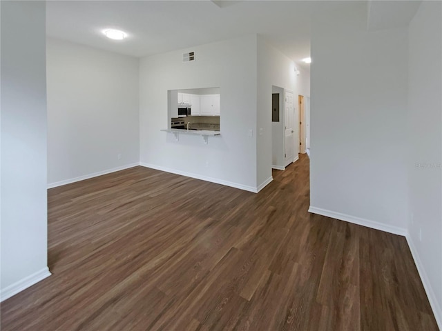 unfurnished living room with electric panel and dark wood-type flooring