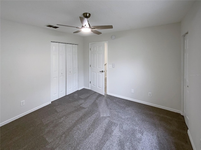 unfurnished bedroom featuring dark carpet, ceiling fan, and a closet