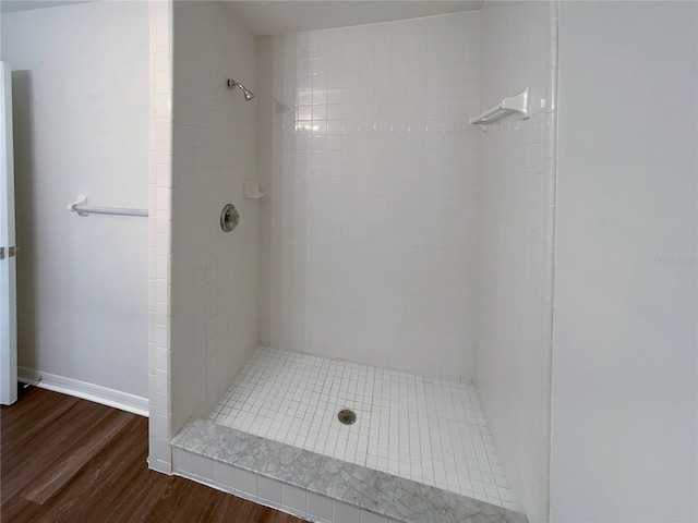 bathroom featuring tiled shower and wood-type flooring