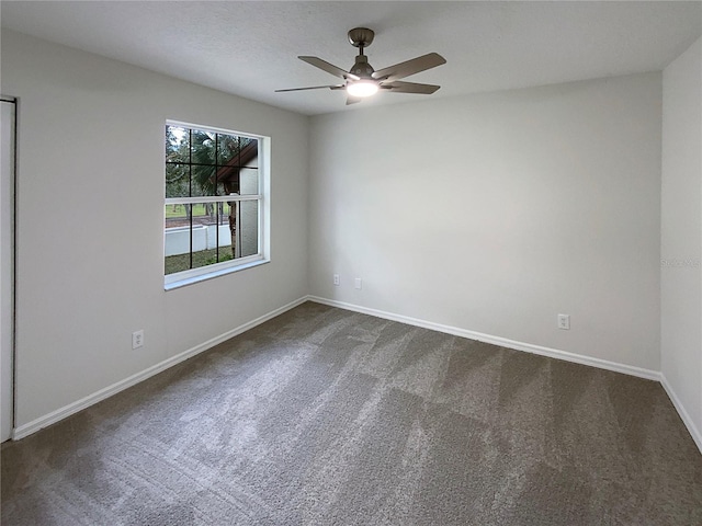 carpeted spare room featuring ceiling fan