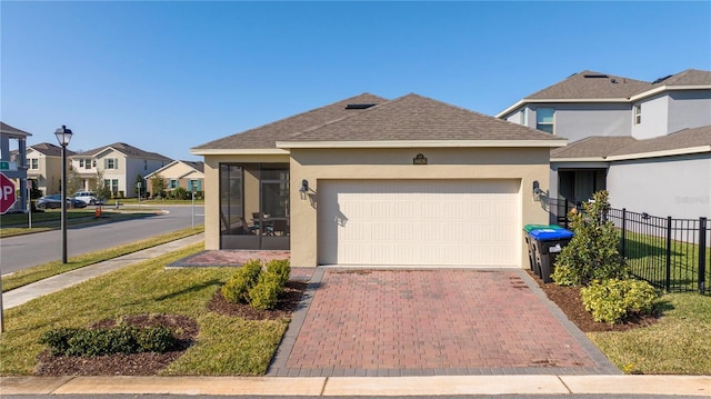 view of front of home with a garage and a sunroom