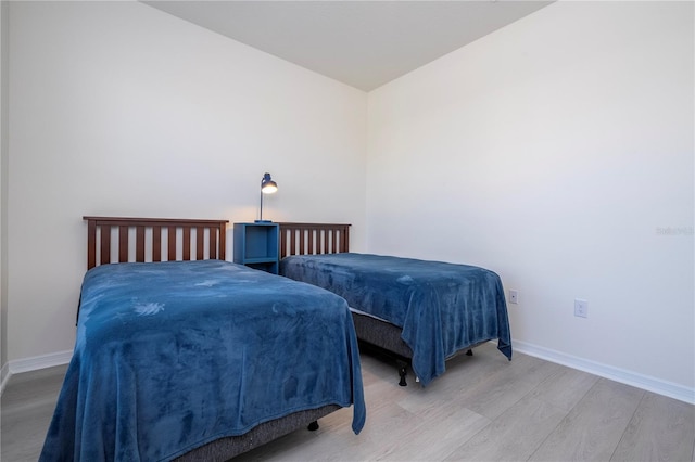 bedroom featuring vaulted ceiling and light hardwood / wood-style flooring