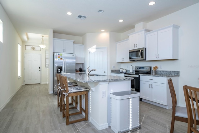 kitchen featuring white cabinetry, a kitchen island with sink, and appliances with stainless steel finishes