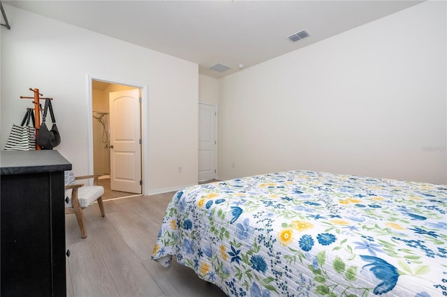 bedroom featuring a walk in closet and light wood-type flooring