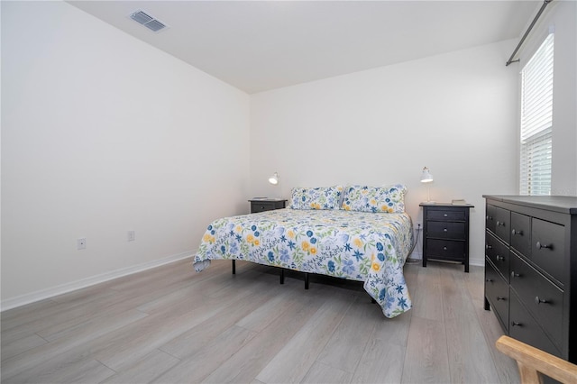 bedroom with light wood-type flooring and multiple windows