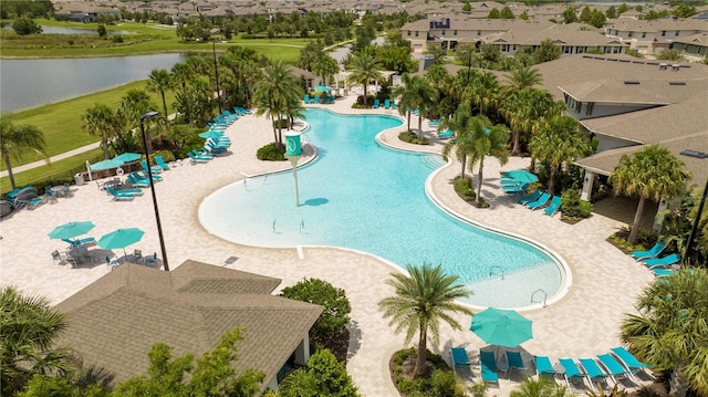 view of pool with a patio and a water view