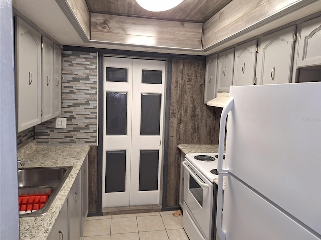 kitchen featuring white appliances, a tray ceiling, light tile patterned flooring, wooden ceiling, and sink