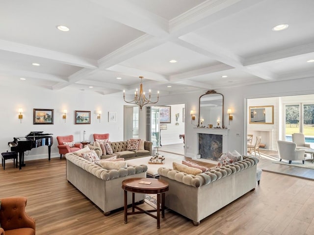 living room featuring coffered ceiling, beam ceiling, a premium fireplace, and light wood-type flooring