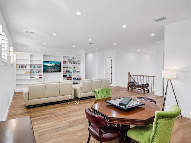 living room with light wood-type flooring and built in features