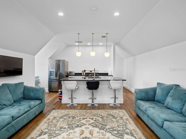 living room with sink, hardwood / wood-style floors, and vaulted ceiling