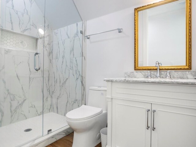 bathroom with toilet, wood-type flooring, an enclosed shower, and vanity