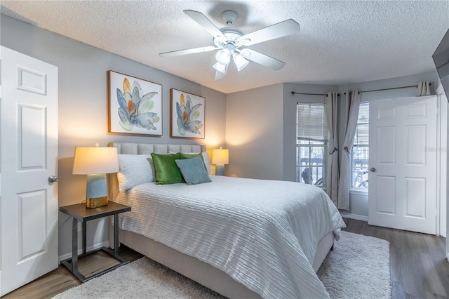 bedroom featuring access to outside, hardwood / wood-style flooring, a textured ceiling, and ceiling fan