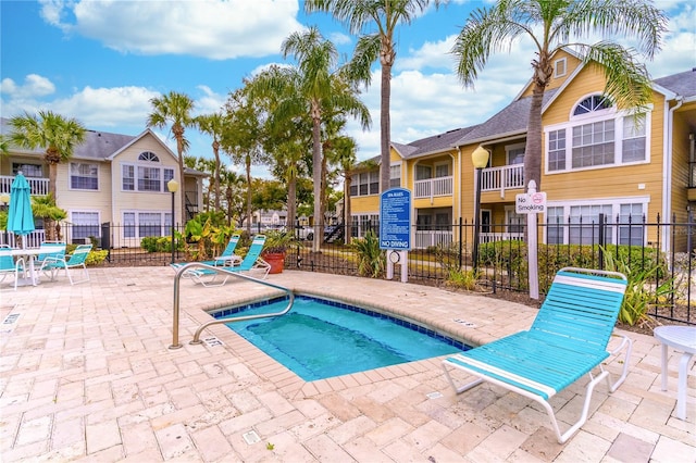 view of pool with a hot tub and a patio