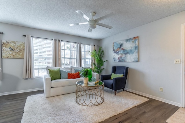 living room featuring dark wood finished floors, plenty of natural light, a ceiling fan, a textured ceiling, and baseboards