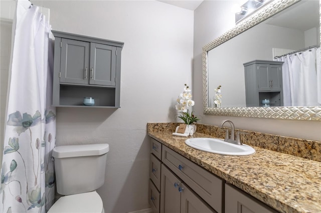 bathroom featuring toilet, vanity, and curtained shower