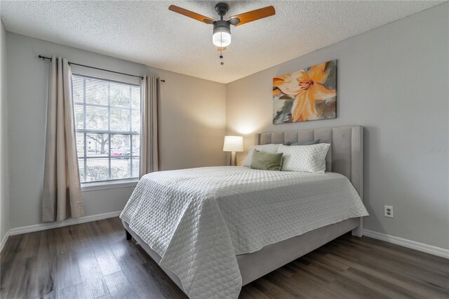 bedroom featuring baseboards, wood finished floors, a textured ceiling, and a ceiling fan