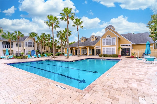 community pool with fence and a patio area