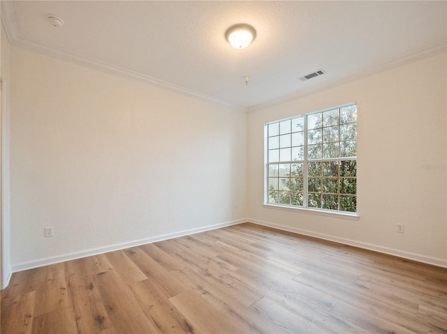 unfurnished room featuring light wood-type flooring, a wealth of natural light, and ornamental molding